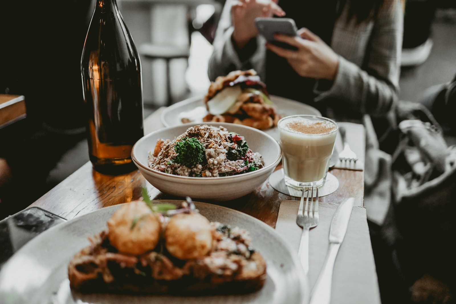 Services woman in gray cardigan holding phone